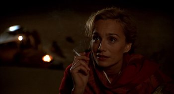 Movie still from “The English Patient” (1996), directed by Anthony Minghella – A woman is smoking a cigarette in a dark room; Close Up shot, Over the shoulder angle