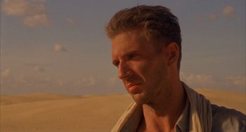 Movie still from “The English Patient” (1996), directed by Anthony Minghella – A person in a field with a sky in the background; Close Up shot, Low angle