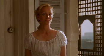 Movie still from “The English Patient” (1996), directed by Anthony Minghella – A woman in a white dress standing in front of a window; Medium shot, Over the shoulder angle