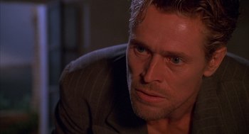 Movie still from “The English Patient” (1996), directed by Anthony Minghella – A person wearing a suit and tie; Close Up shot, Over the shoulder angle