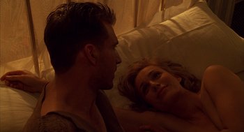 Movie still from “The English Patient” (1996), directed by Anthony Minghella – A man and a woman laying in a bed together; Close Up shot, Overhead angle