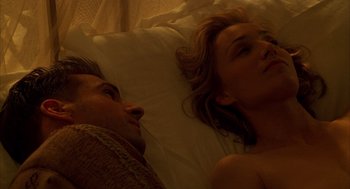 Movie still from “The English Patient” (1996), directed by Anthony Minghella – A man and a woman laying in bed together; Close Up shot, Overhead angle