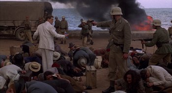 Movie still from “The English Patient” (1996), directed by Anthony Minghella – A group of people sitting on the beach; Wide shot, High angle