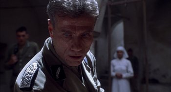 Movie still from “The English Patient” (1996), directed by Anthony Minghella – An older man in a military uniform looking at the camera; Close Up shot, Low angle