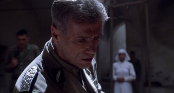 Movie still from “The English Patient” (1996), directed by Anthony Minghella – An older man in a uniform looking down at the ground; Close Up shot, Low angle