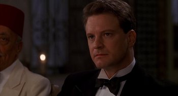 Movie still from “The English Patient” (1996), directed by Anthony Minghella – A person wearing a suit and a bow tie; Close Up shot, Over the shoulder angle