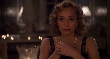Movie still from “The English Patient” (1996), directed by Anthony Minghella – A woman in a black dress holding a pearl necklace; Close Up shot, Over the shoulder angle