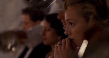 Movie still from “The English Patient” (1996), directed by Anthony Minghella – A group of people that are sitting in a room; Close Up shot, Over the shoulder angle
