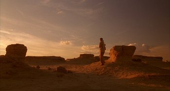 Movie still from “The English Patient” (1996), directed by Anthony Minghella – A person standing in the desert at sunset; Extreme Wide shot, Low angle