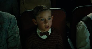 Movie still from “The Fabelmans” (2022), directed by Steven Spielberg – A young boy wearing a bow tie sitting in a chair; Close Up shot, High angle