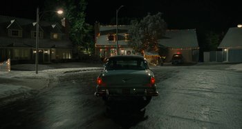 Movie still from “The Fabelmans” (2022), directed by Steven Spielberg – A car is driving down the street at night; Extreme Wide shot, High angle