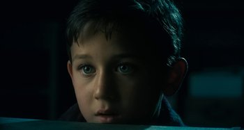 Movie still from “The Fabelmans” (2022), directed by Steven Spielberg – A young boy with blue eyes stares into the camera; Close Up shot, High angle