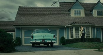 Movie still from “The Fabelmans” (2022), directed by Steven Spielberg – An old car is parked in front of a house; Wide shot, Low angle