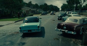 Movie still from “The Fabelmans” (2022), directed by Steven Spielberg – A group of cars driving down a street; Wide shot, High angle