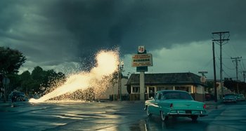 Movie still from “The Fabelmans” (2022), directed by Steven Spielberg – An old car is parked on the side of the road; Extreme Wide shot, Low angle