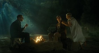 Movie still from “The Fabelmans” (2022), directed by Steven Spielberg – A group of people sitting around a fire pit at night; Wide shot, Over the shoulder angle