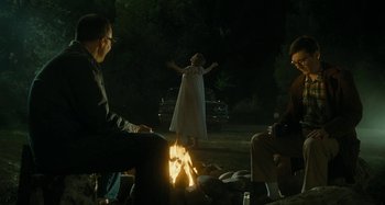 Movie still from “The Fabelmans” (2022), directed by Steven Spielberg – A group of people sitting around a fire pit at night; Wide shot, Low angle