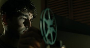 Movie still from “The Fabelmans” (2022), directed by Steven Spielberg – A young man looking at a movie projector; Close Up shot, Low angle