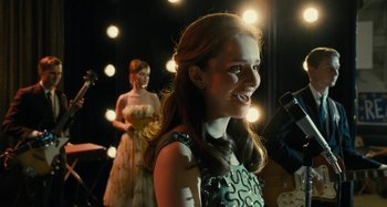 Movie still from “The Fabelmans” (2022), directed by Steven Spielberg – A woman standing in front of a microphone in front of another woman; Medium shot, Over the shoulder angle