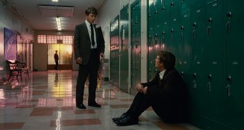 Movie still from “The Fabelmans” (2022), directed by Steven Spielberg – Two young men in suits and ties in front of lockers; Wide shot, Low angle