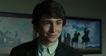 Movie still from “The Fabelmans” (2022), directed by Steven Spielberg – A man in a suit and tie smiling for the camera; Close Up shot, Over the shoulder angle