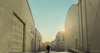 Movie still from “The Fabelmans” (2022), directed by Steven Spielberg – A person walking down a street near a building; Extreme Wide shot, Low angle