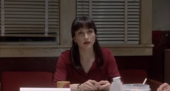 Movie still from “The Faculty” (1998), directed by Robert Rodriguez – A woman sitting at a table in front of a window; Close Up shot, Low angle