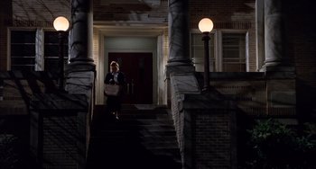 Movie still from “The Faculty” (1998), directed by Robert Rodriguez – A woman walking down the stairs of a building; Wide shot, Low angle