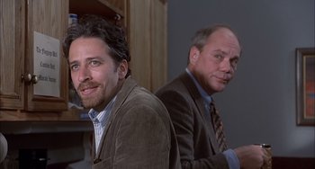 Movie still from “The Faculty” (1998), directed by Robert Rodriguez – Two men in suits and ties sitting next to each other; Close Up shot, Over the shoulder angle