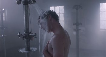 Movie still from “The Faculty” (1998), directed by Robert Rodriguez – A man is taking a shower in a bathroom; Medium shot, Low angle
