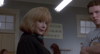 Movie still from “The Faculty” (1998), directed by Robert Rodriguez – A woman with blonde hair is standing in a room; Close Up shot, Low angle