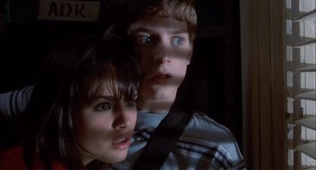 Movie still from “The Faculty” (1998), directed by Robert Rodriguez – A young man and woman are posing for a picture; Close Up shot, Low angle