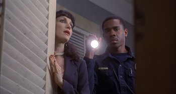 Movie still from “The Faculty” (1998), directed by Robert Rodriguez – A man and a woman are holding a flashlight; Medium shot, Low angle