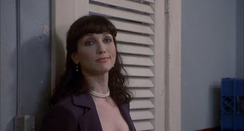 Movie still from “The Faculty” (1998), directed by Robert Rodriguez – A woman in a purple jacket standing in front of a window; Close Up shot, Over the shoulder angle