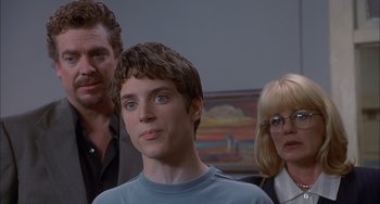 Movie still from “The Faculty” (1998), directed by Robert Rodriguez – A young man and two older women standing next to him; Close Up shot, Over the shoulder angle