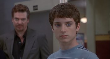 Movie still from “The Faculty” (1998), directed by Robert Rodriguez – A young man with blue eyes stares into the camera; Close Up shot, Over the shoulder angle