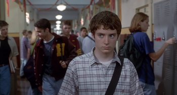 Movie still from “The Faculty” (1998), directed by Robert Rodriguez – A young man in a plaid shirt is standing in a hallway; Close Up shot, Low angle