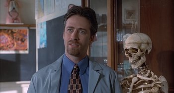 Movie still from “The Faculty” (1998), directed by Robert Rodriguez – A man in a lab coat standing in front of a skeleton; Close Up shot, Low angle