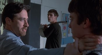 Movie still from “The Faculty” (1998), directed by Robert Rodriguez – A man holding a baseball bat over another man's head; Close Up shot, Over the shoulder angle