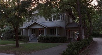 Movie still from “The Faculty” (1998), directed by Robert Rodriguez – A house that has a lot of trees in front of it; Wide shot, High angle