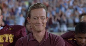 Movie still from “The Faculty” (1998), directed by Robert Rodriguez – A person wearing a maroon shirt smiling; Close Up shot, Low angle