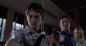 Movie still from “The Faculty” (1998), directed by Robert Rodriguez – A group of young men holding guns in a room; Close Up shot, Low angle
