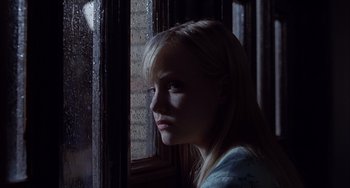 Movie still from “The Faculty” (1998), directed by Robert Rodriguez – A woman sitting in front of a window looking out of the window; Close Up shot, Low angle