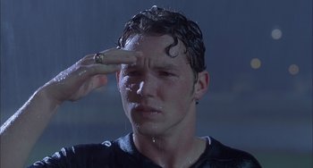 Movie still from “The Faculty” (1998), directed by Robert Rodriguez – A man with a wet shirt on touching his forehead with one hand; Close Up shot, Low angle