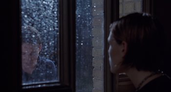 Movie still from “The Faculty” (1998), directed by Robert Rodriguez – A man looking out of a window at a woman; Medium shot, Over the shoulder angle
