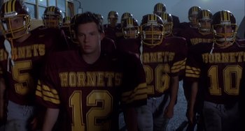 Movie still from “The Faculty” (1998), directed by Robert Rodriguez – A group of football players are lined up for a team photo; Medium shot, Low angle