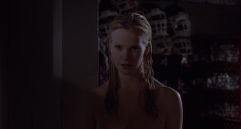 Movie still from “The Faculty” (1998), directed by Robert Rodriguez – A woman standing in a dark room in front of a wall; Close Up shot, Over the shoulder angle
