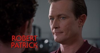 Movie still from “The Faculty” (1998), directed by Robert Rodriguez – A man's face with the name " robert patrick " below it; Close Up shot, Over the shoulder angle