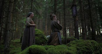 Movie still from “The Field Guide to Evil” (2018), directed by Can Evrenol – Two women dressed in medieval garb standing in the woods; Wide shot, Low angle
