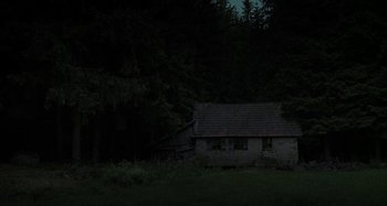 Movie still from “The Field Guide to Evil” (2018), directed by Can Evrenol – An old house in the middle of the night; Extreme Wide shot, Low angle